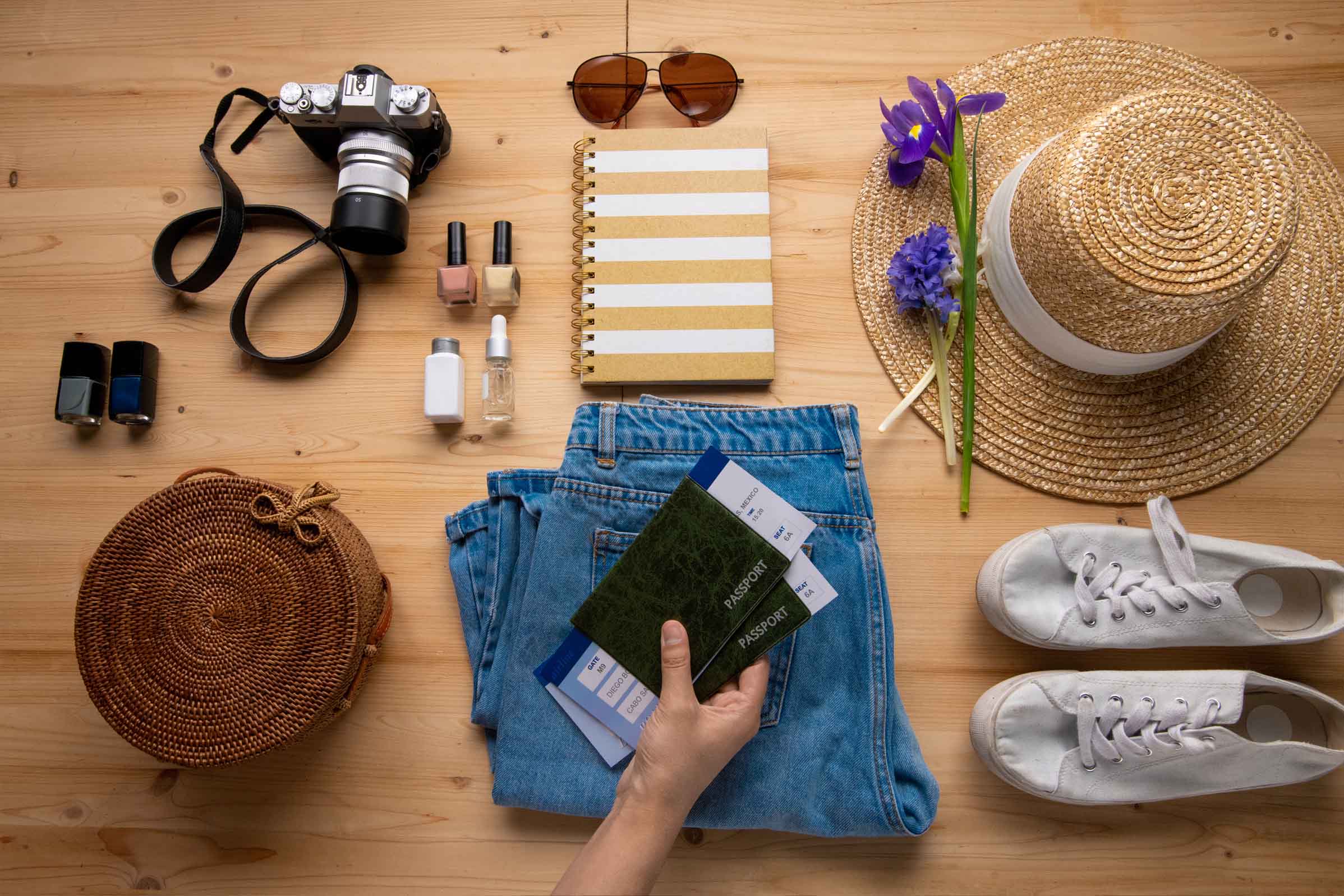 Travel desk flatlay with passport, camera, and notebook